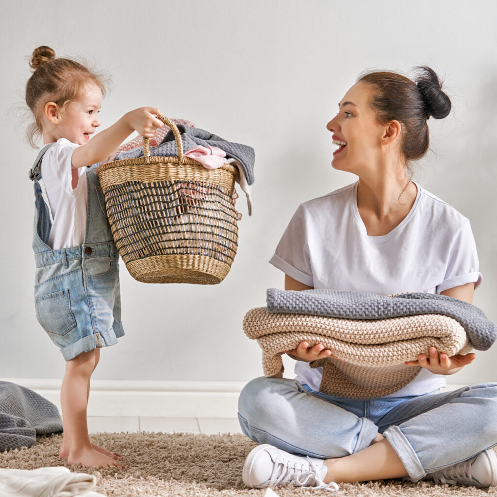 mother folding clothes with her child