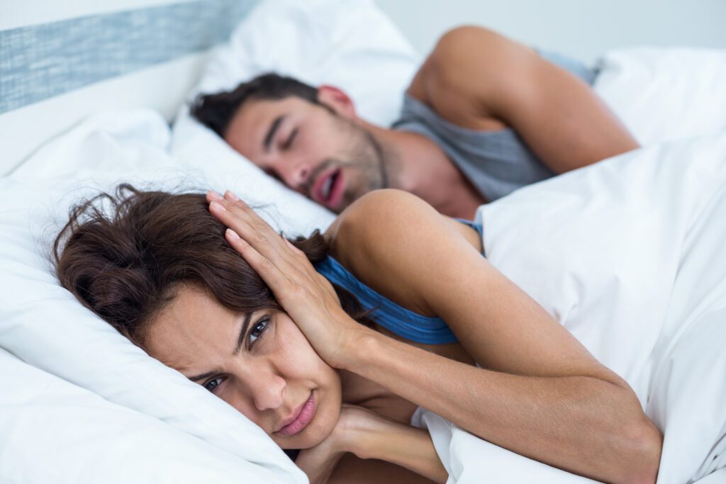 woman annoyed at her husband snoring