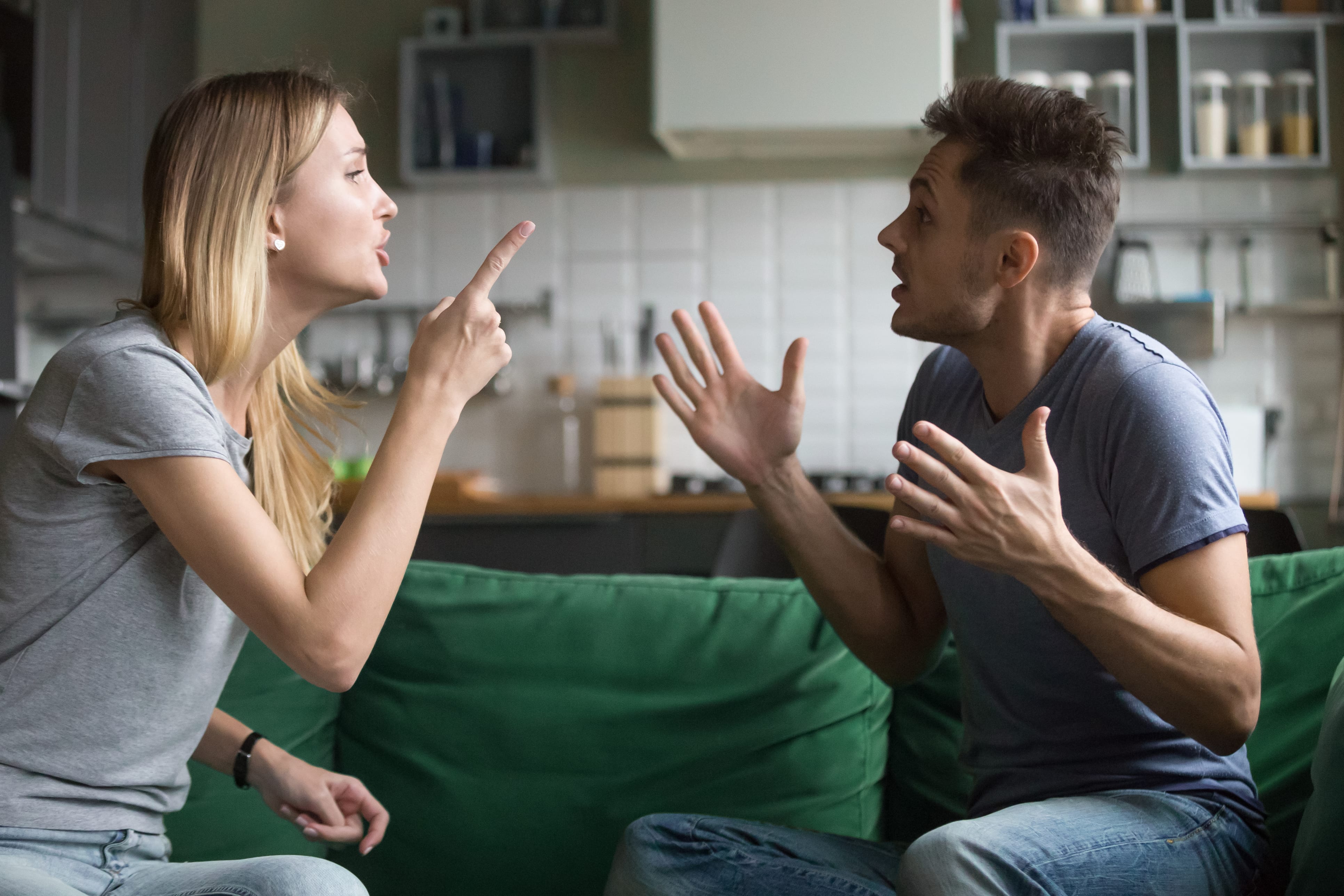 Woman sternly shaking her finger at a man with his hands up