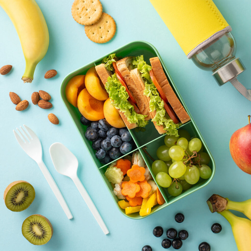 lunch box with healthy fruits and sandwiches
