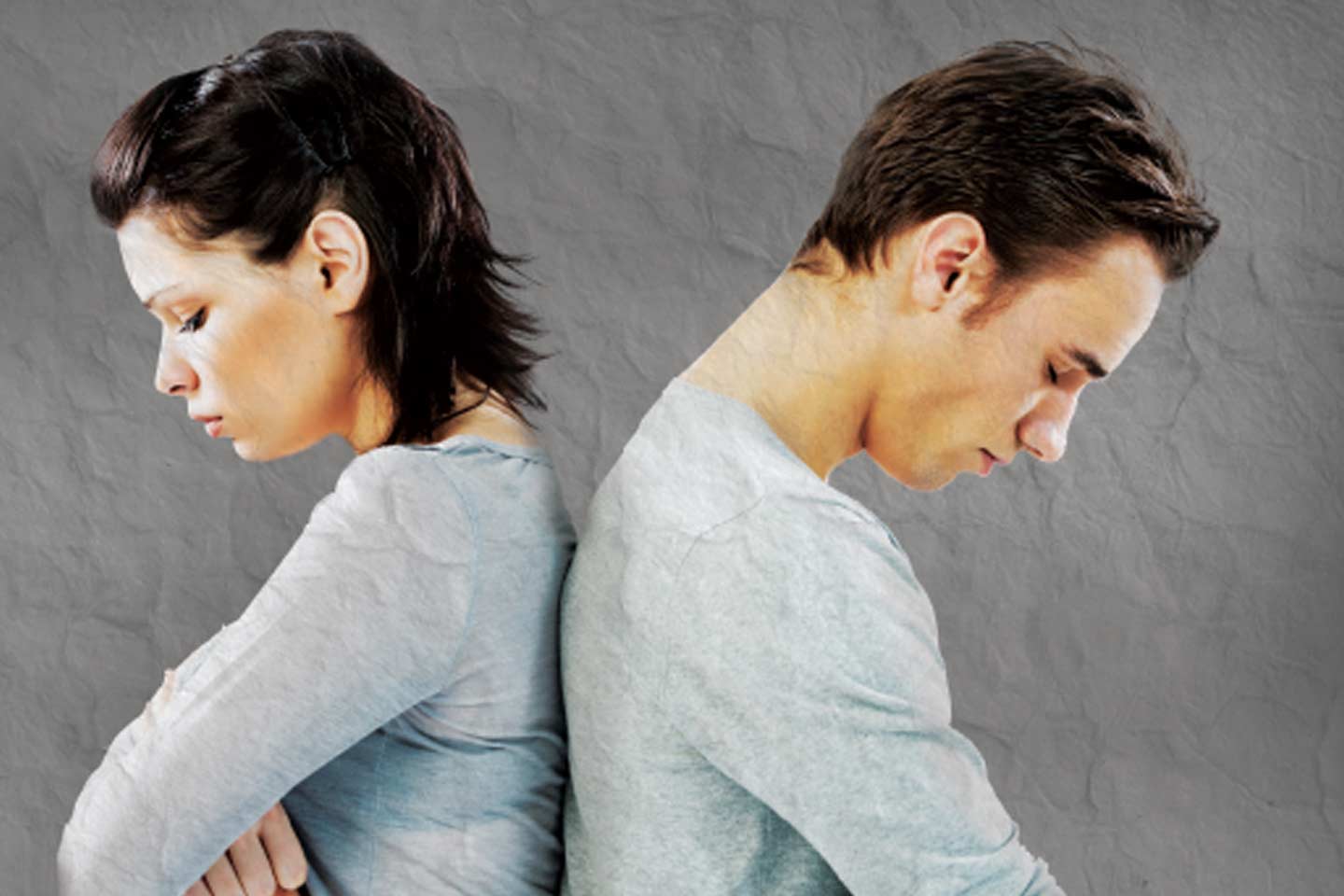 Woman and man with their backs against each other and their heads down