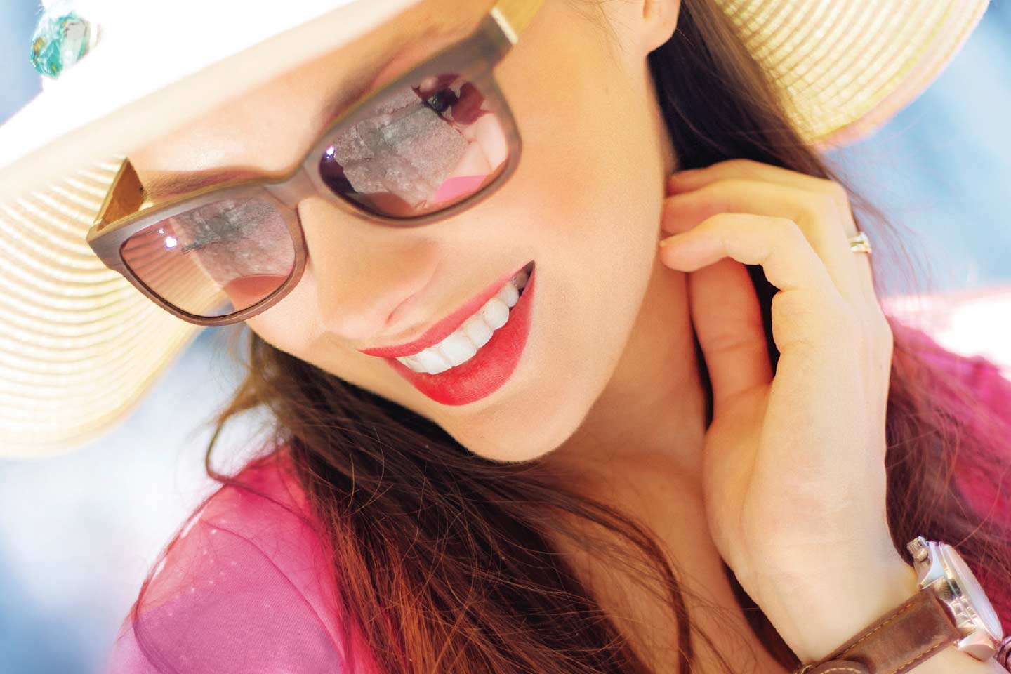 Woman in sunhat and sunglasses smiling