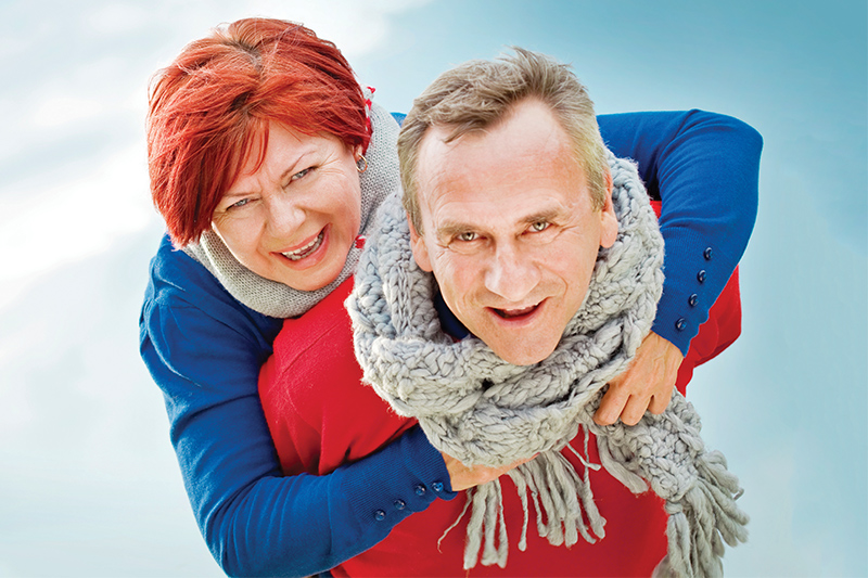 elderly couple with winter clothing smiling