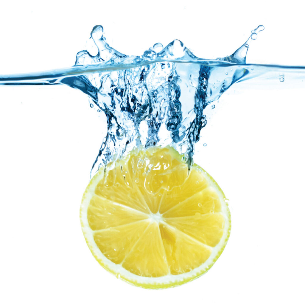 sliced lemon dropped in water