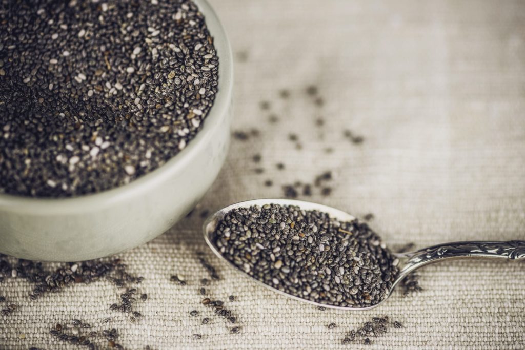 Organic chia seeds in bowl with teaspoon. Superfoods. Healthy eating.