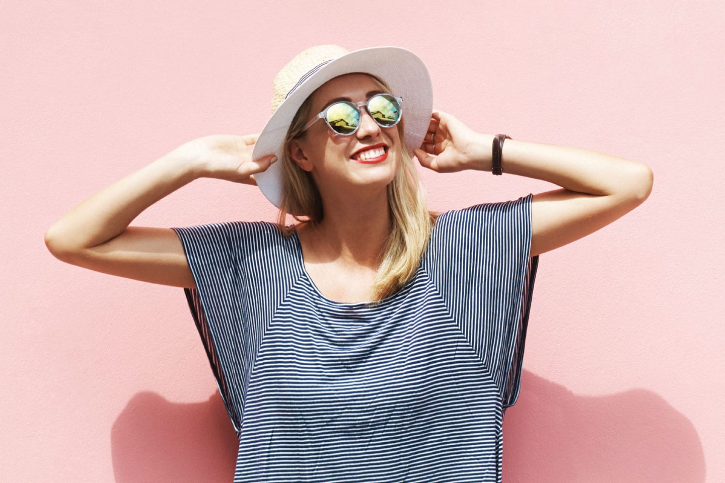 Woman with sun hat and sunglasses looking at the sky