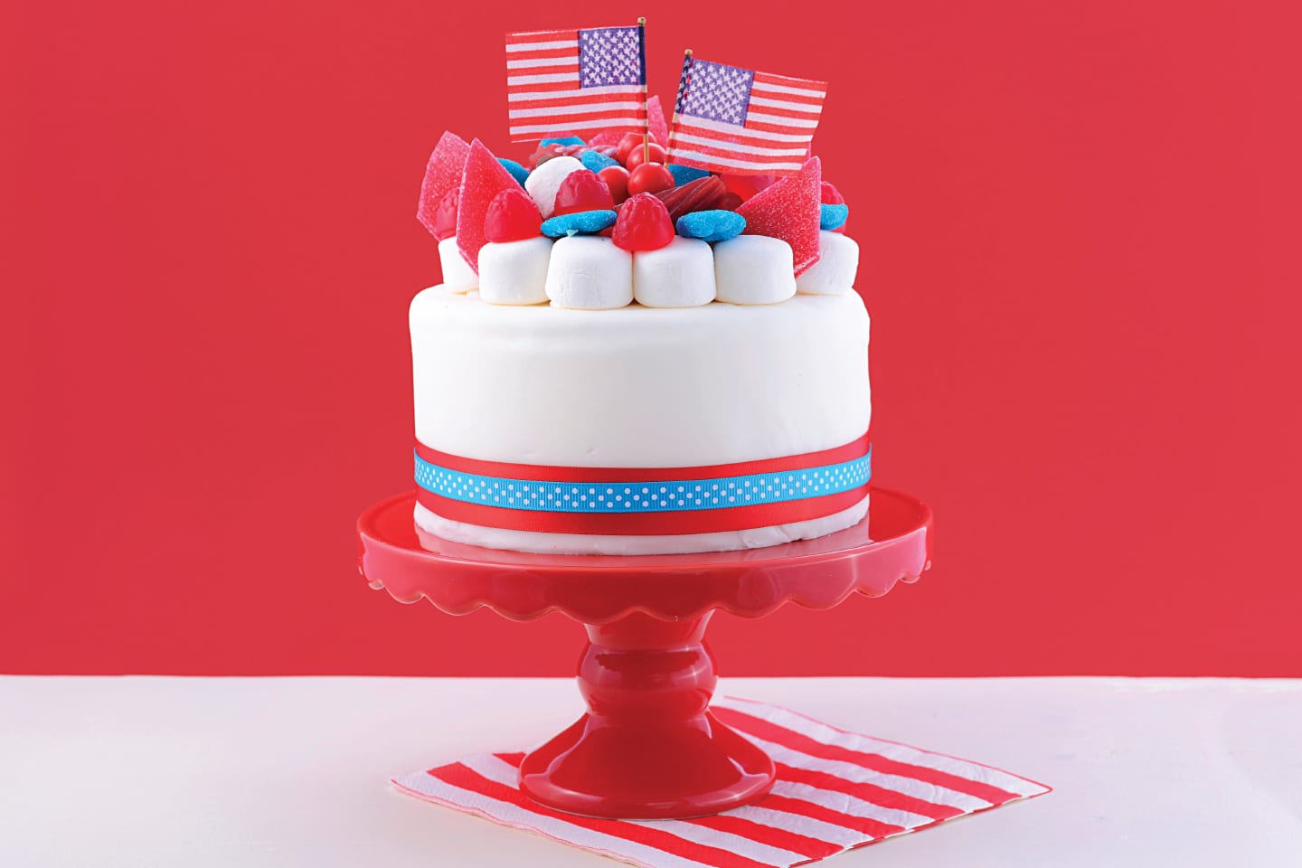 Cake decorated in red, white and blue with American flags on top
