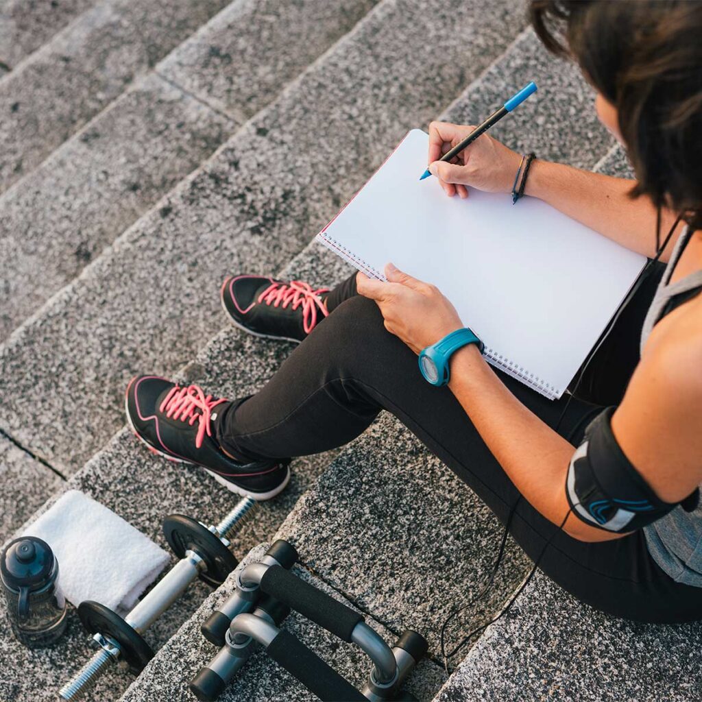 fitness woman writing her goals