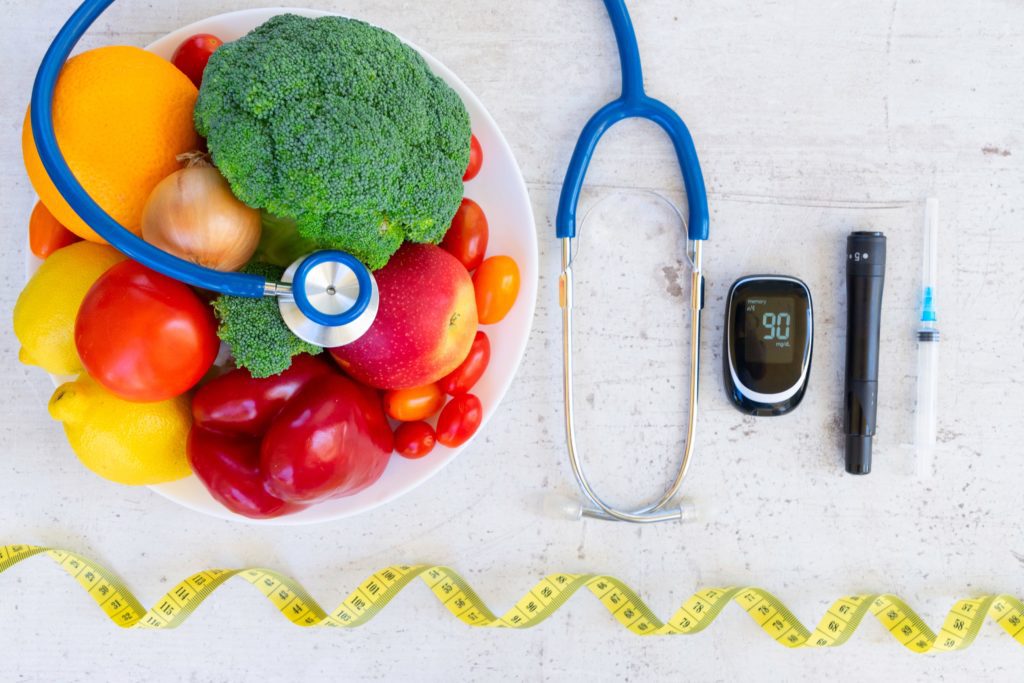 Diabetes healthy diet concept, raw vegetables and fruits with blood glucose meter and insulin syringe