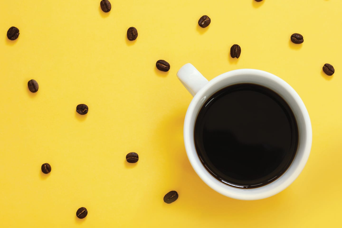 Coffee and coffee beans on a yellow background