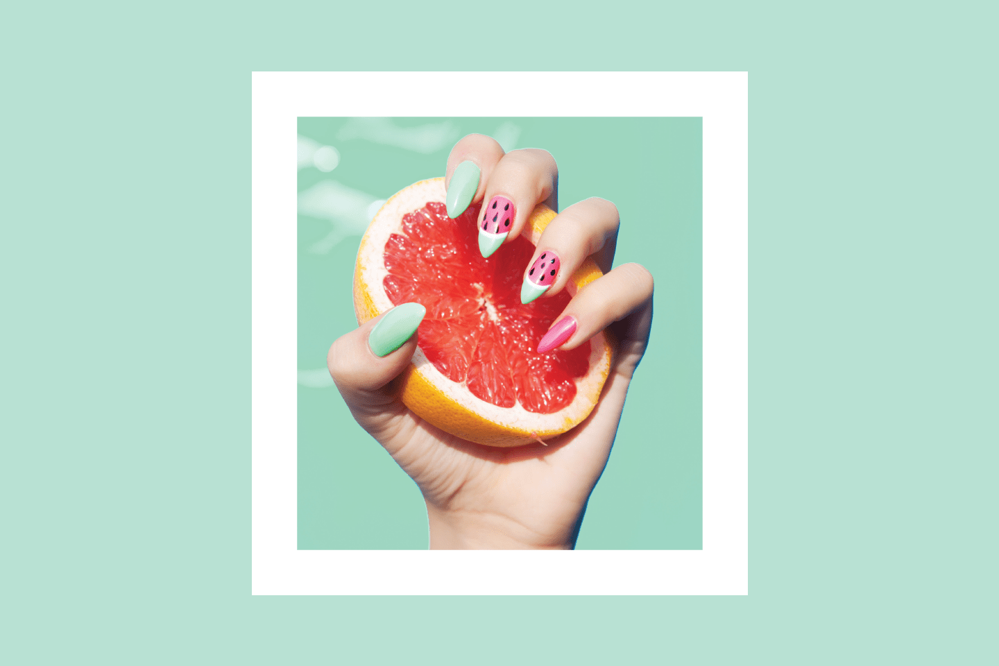Hand with watermelon nail polish clutching a pink grapefruit in chattanooga