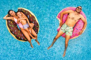 mom dad and son floating on donut inner tubes in the pool in chattanooga