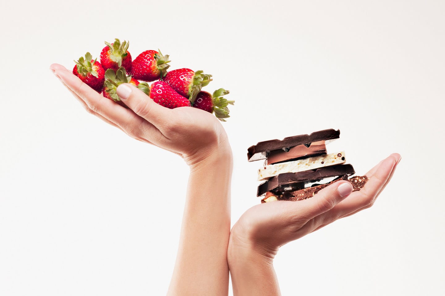 Woman's hands holding up chocolate and strawberries