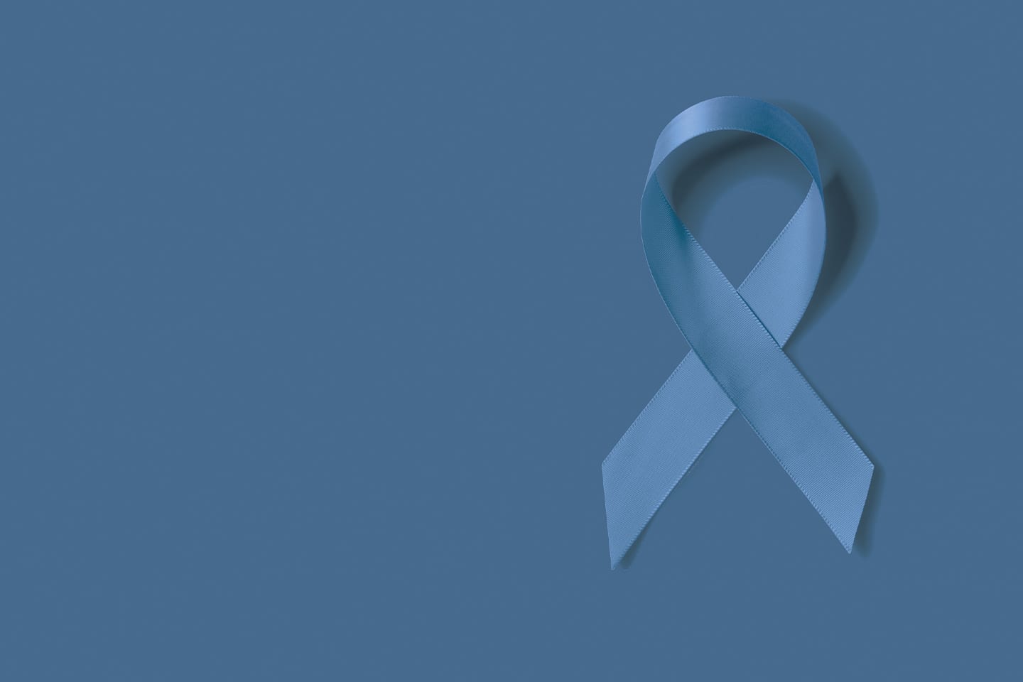 Blue cancer ribbon on blue background for colorectal cancer in chattanooga
