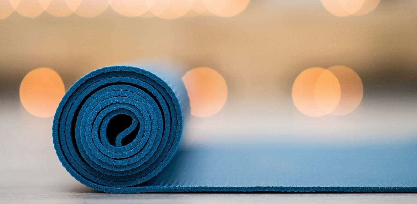 Blue yoga mat partially rolled out