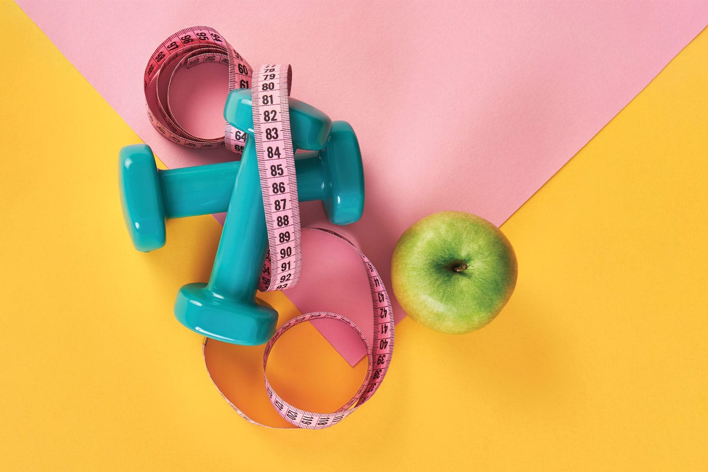 Weights, tape measurer, and a green apple