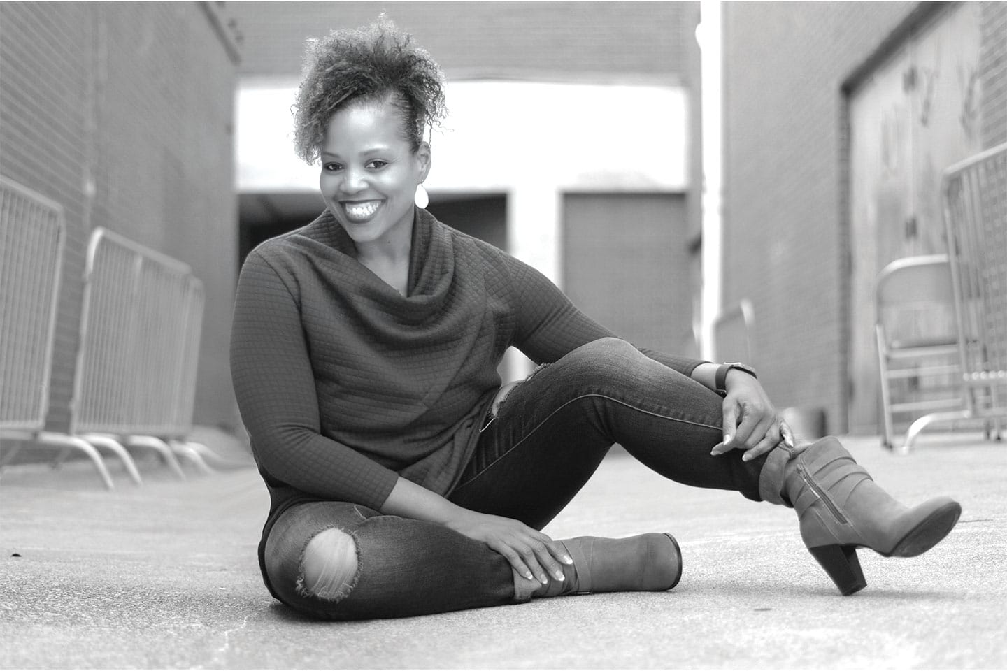Woman sitting on concrete and smiling