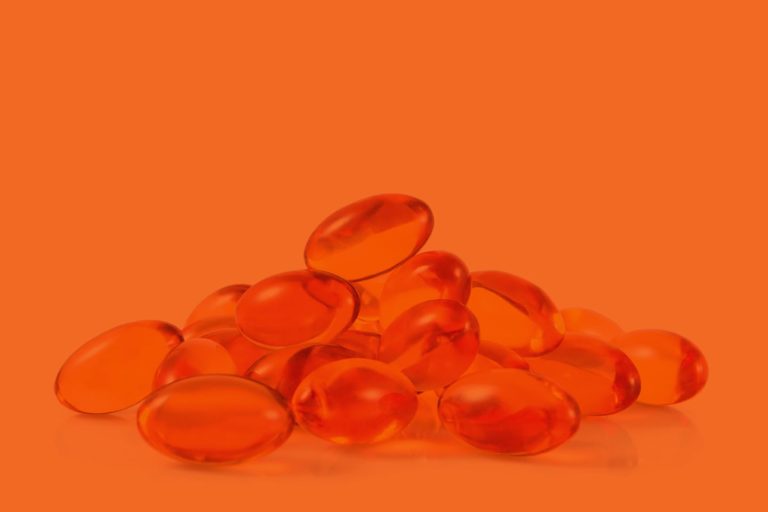 fish oil supplement vitamins on orange background