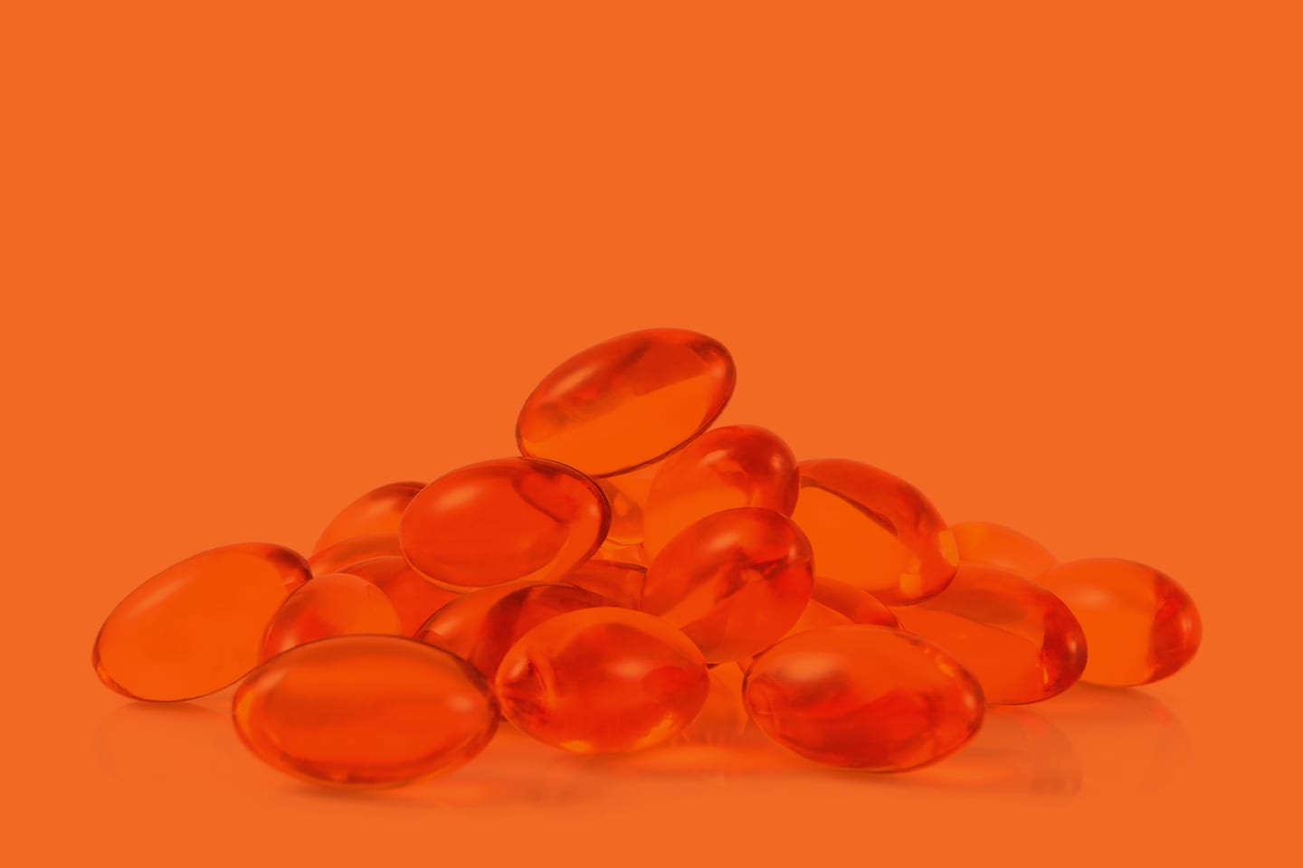 fish oil supplement vitamins on orange background