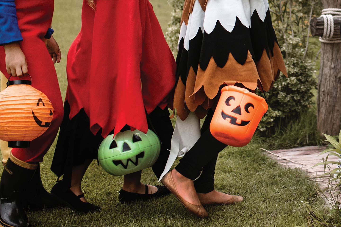 kids trick or treating carrying pumpkin buckets