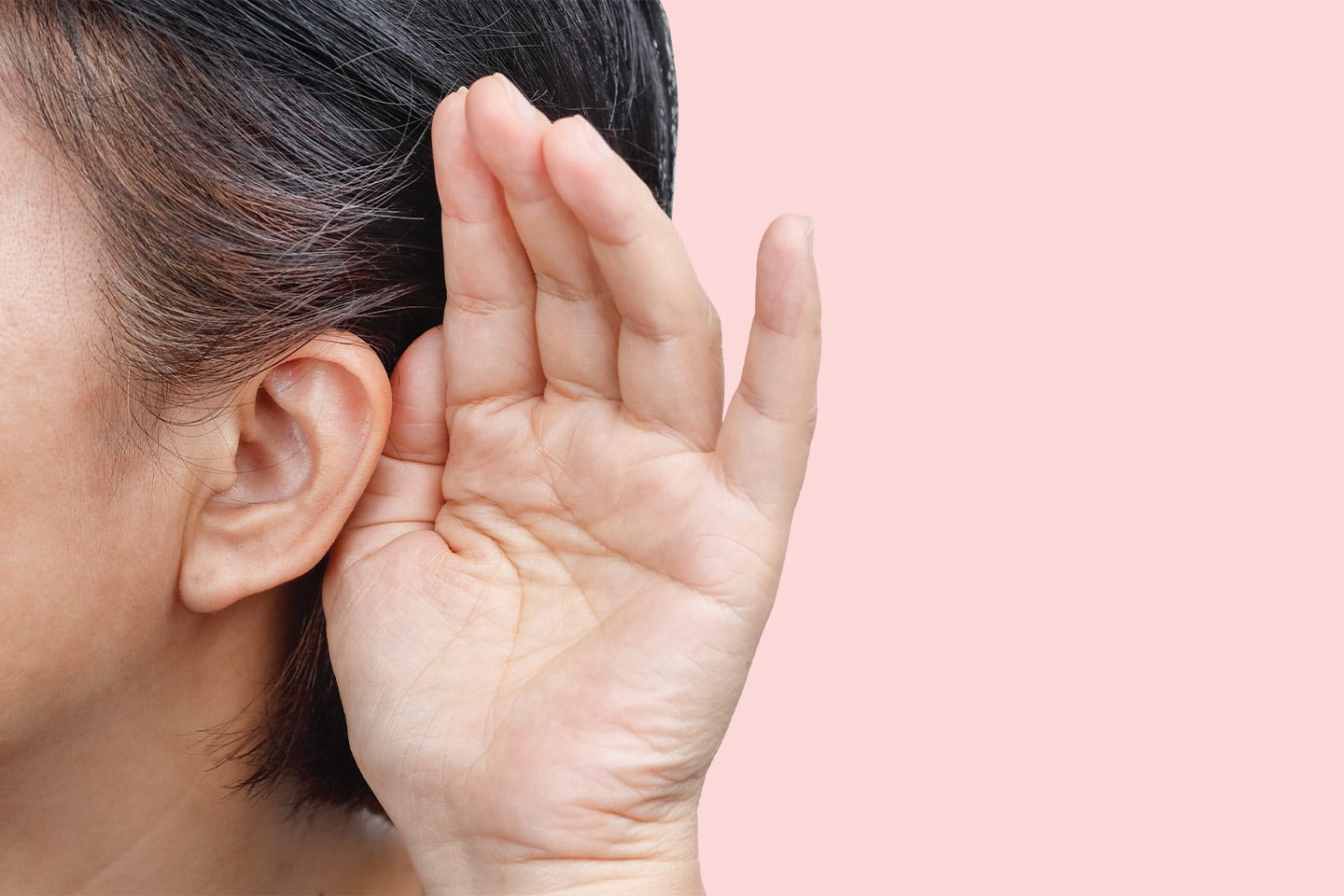 woman with hand to ear because she is hard of hearing