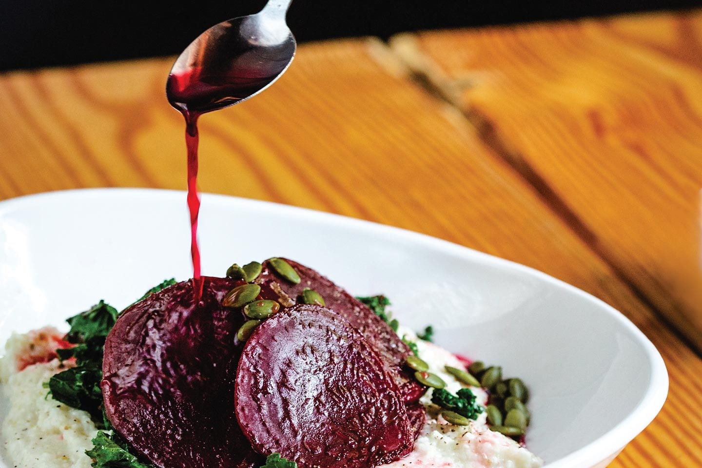 beet reduction sauce being drizzled onto the daily ration's "drop the beet" bowl