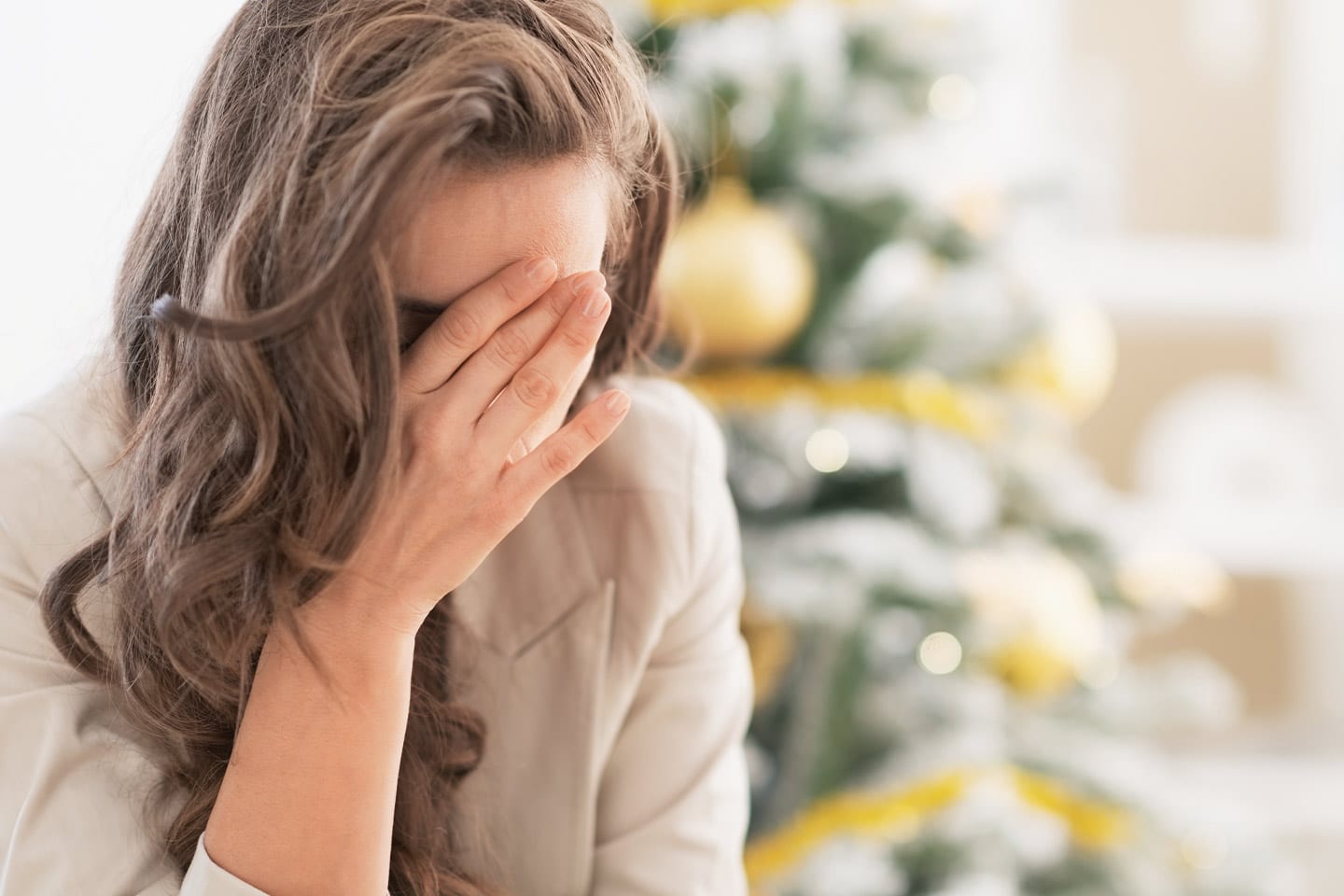 woman upset in front of a christmas tree