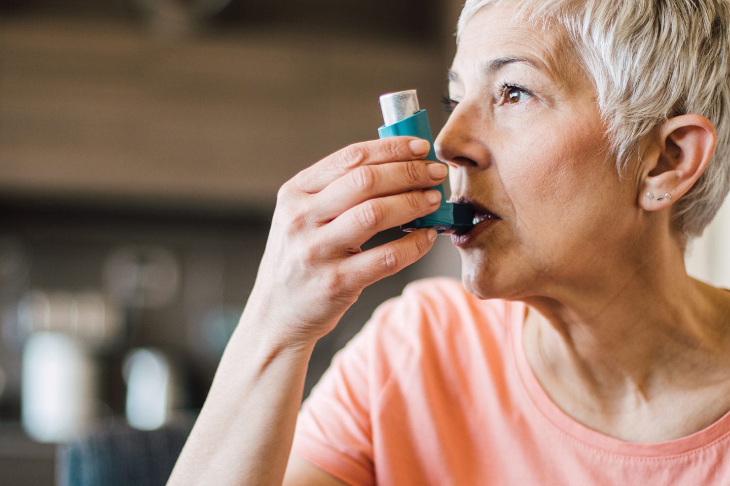 senior adult woman using inhaler