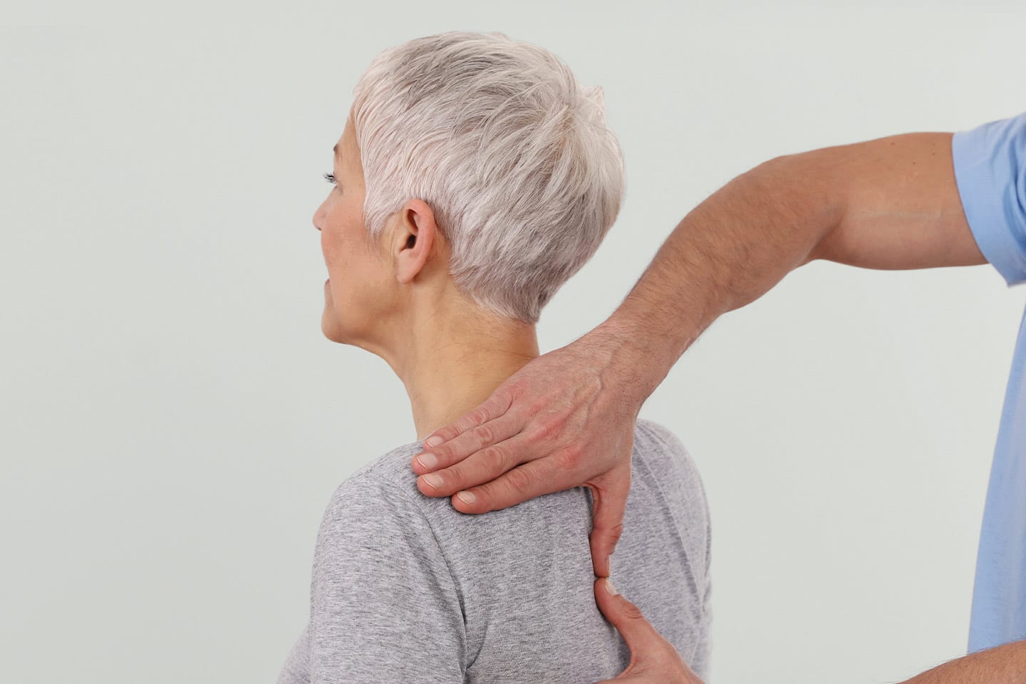 older woman getting checked by doctor for scoliosis