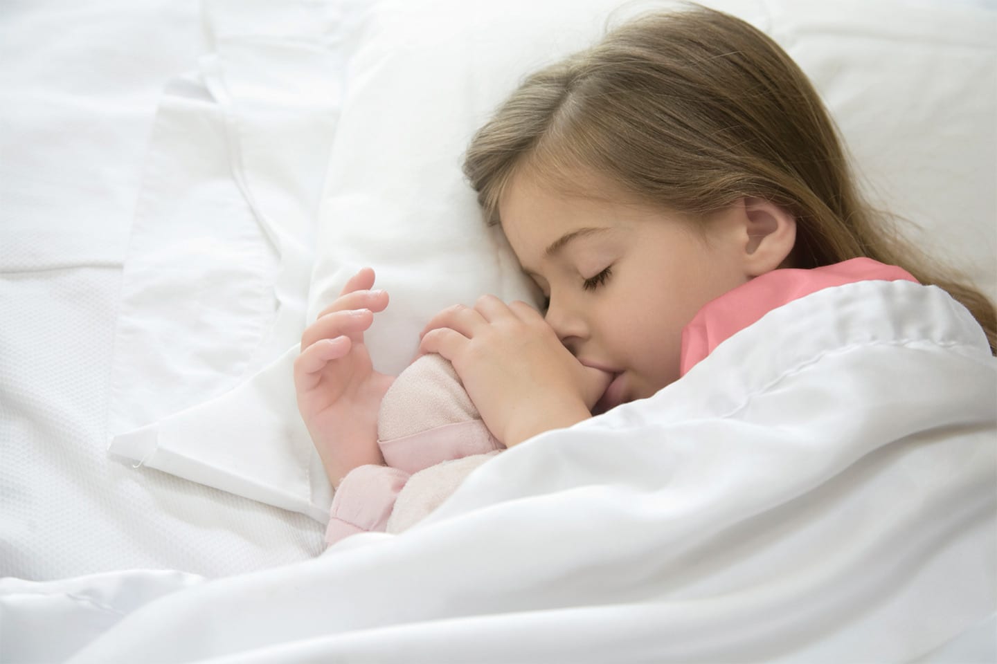 little girl sucking her thumb while she sleeps