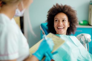 Woman smiling at the dentists office after overcoming dental anxiety