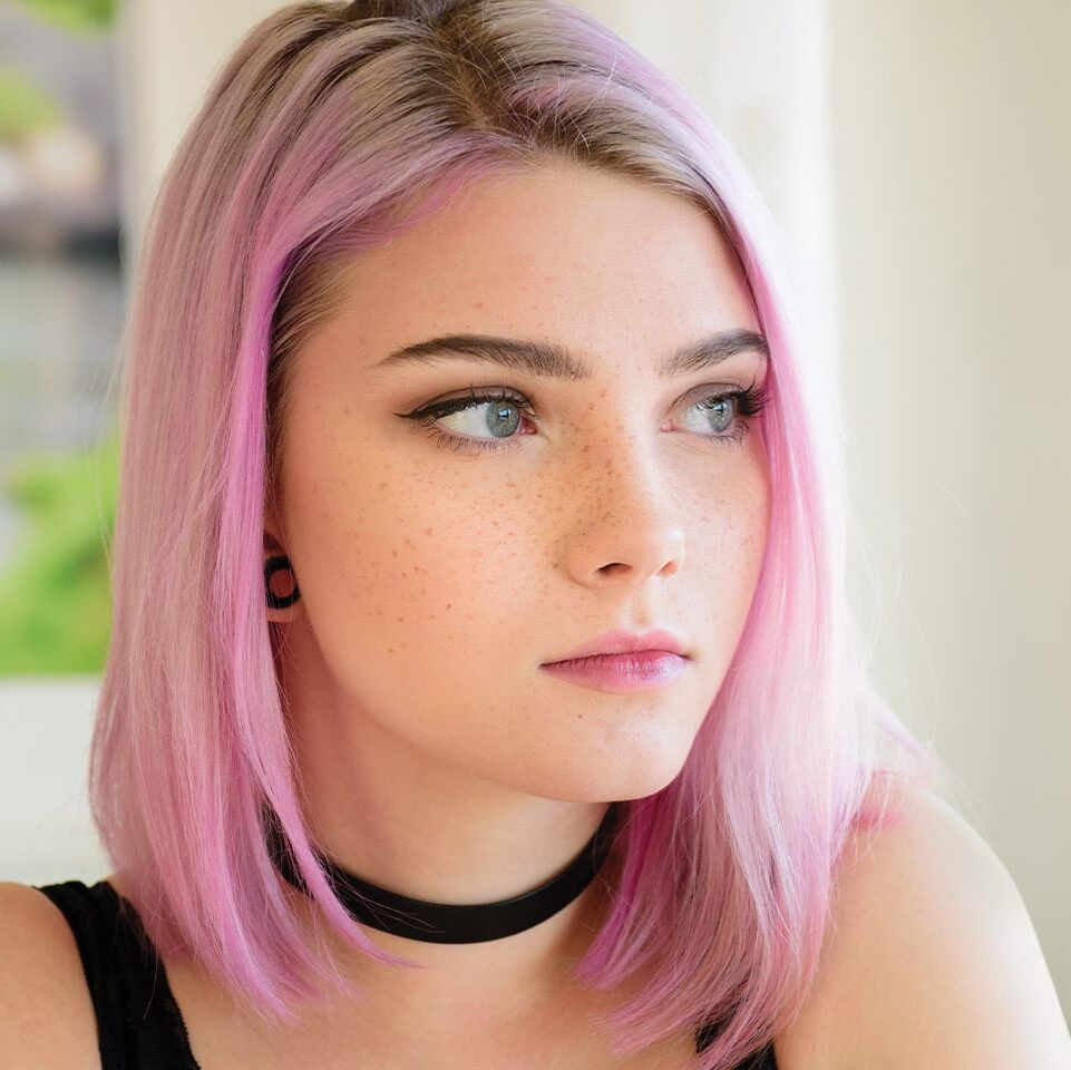 teen girl with pink hair and a ear gage piercing