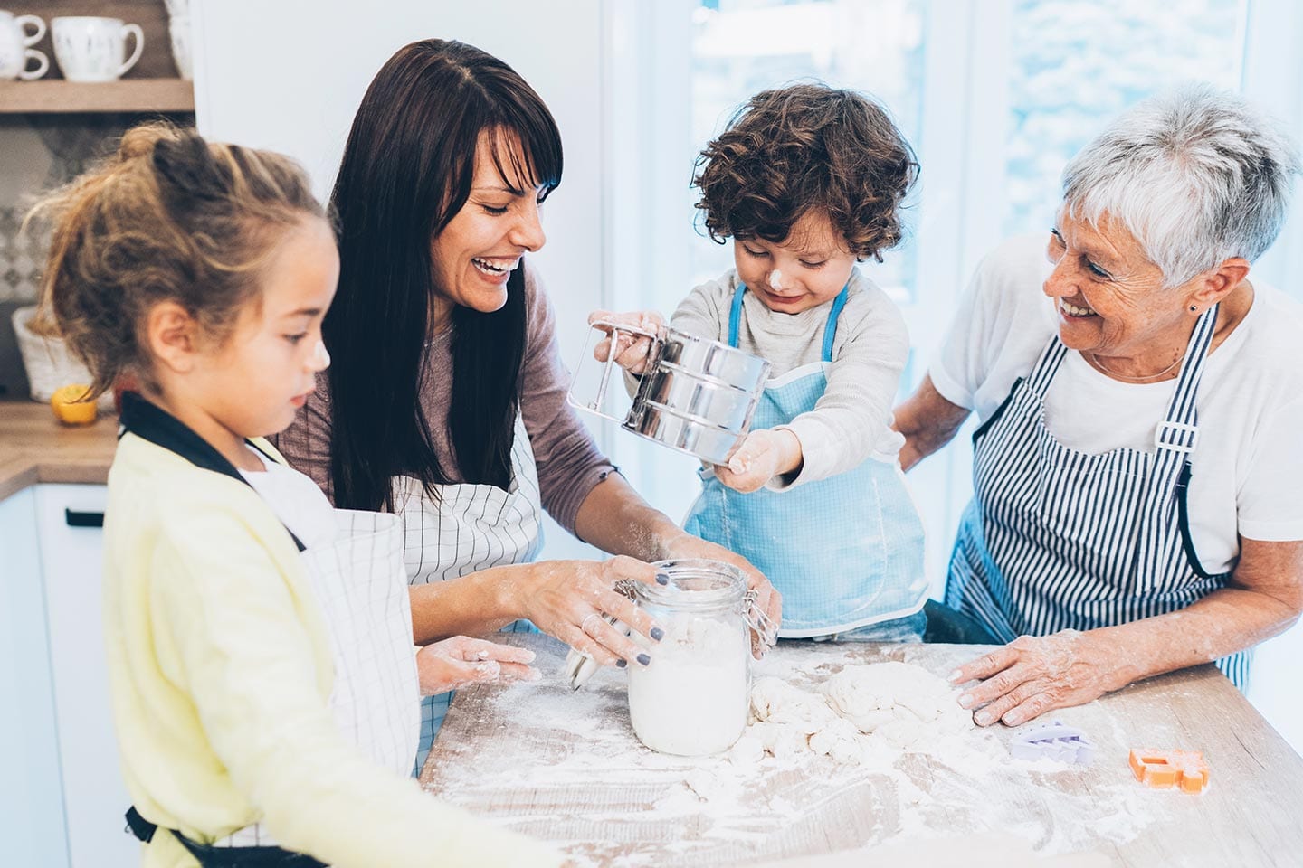 grandma, mom, and children baking together