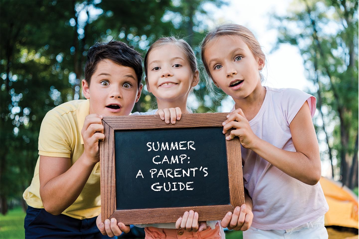 three kids holding a chalk board reading Summer Camp: A Parent's Guide