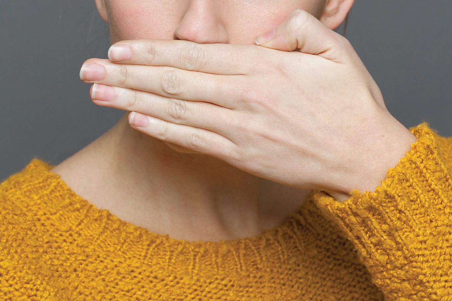 Woman covering her mouth because of unsightly gum disease