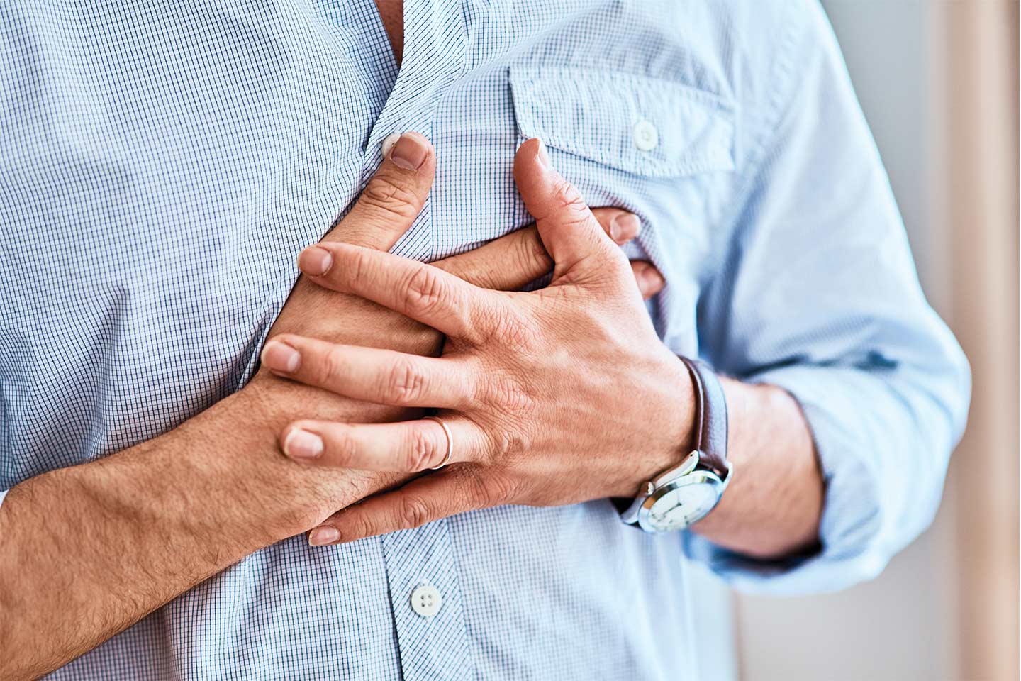 man with hands on chest with heartburn