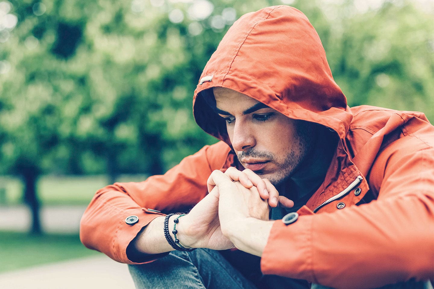 Man struggling with PTSD with a red rain jacket on