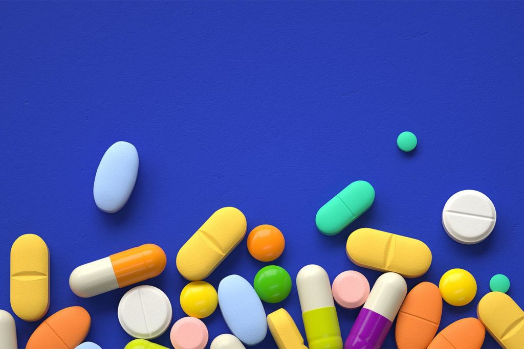 colorful scattered pills on a blue background