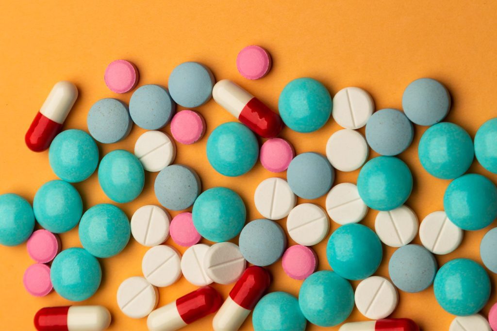 pile of pills and vitamins on an orange background