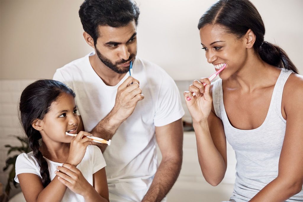 happy family brushing their teeth together