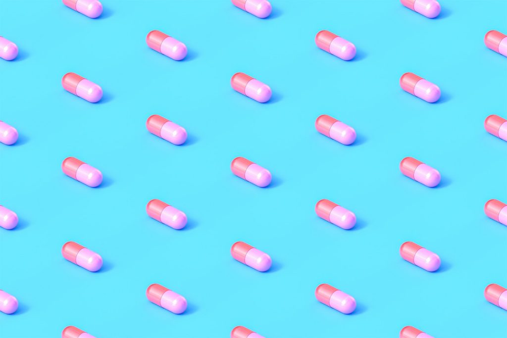 pink and coral pills on a blue background