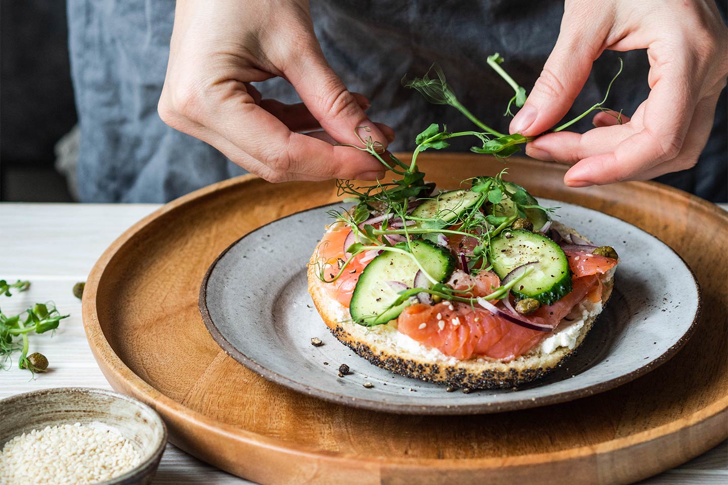woman fixing a bagel with smoked salmon