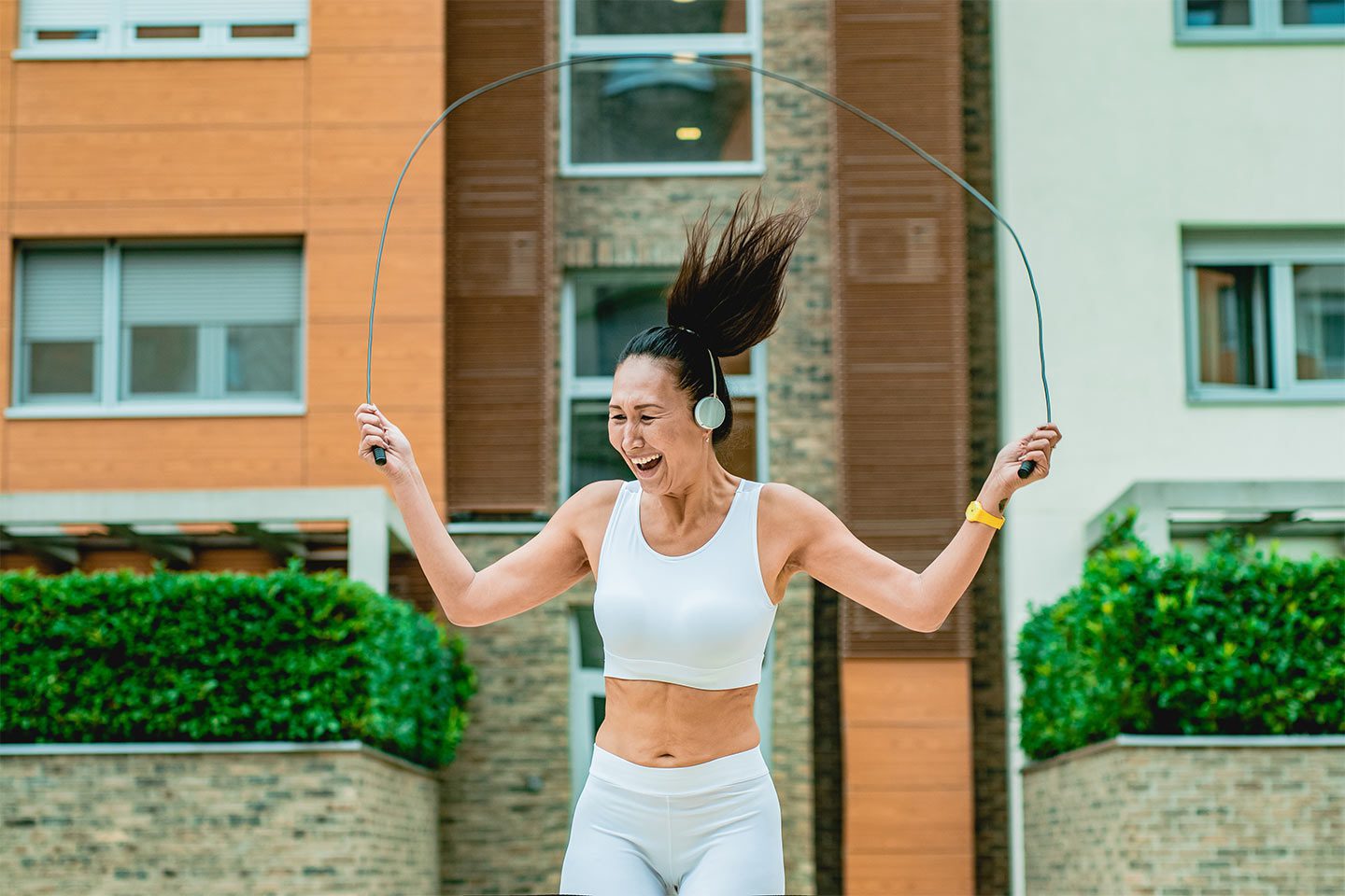 Woman jumping rope outside her home