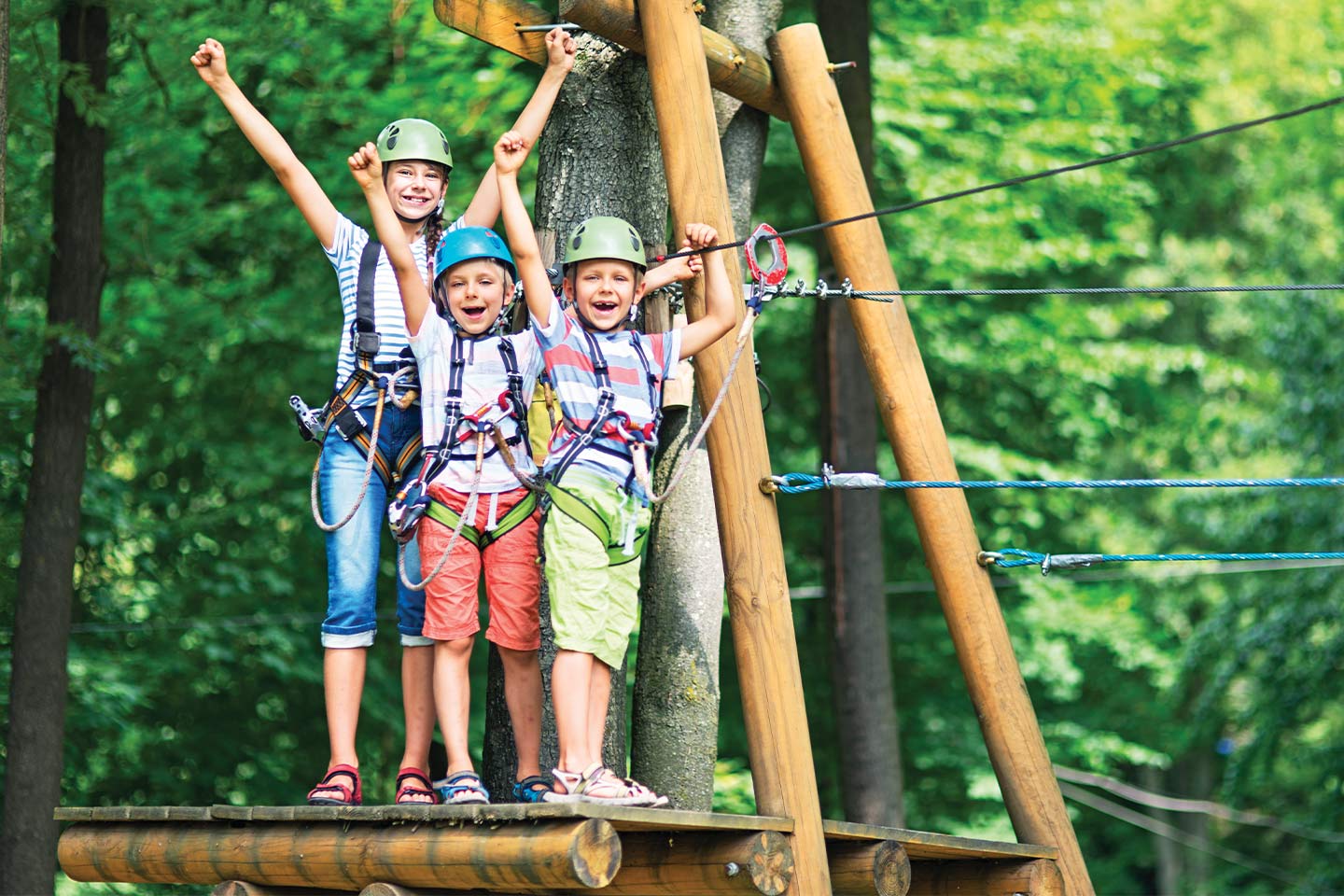 happy kids doing a high ropes course at summer camp