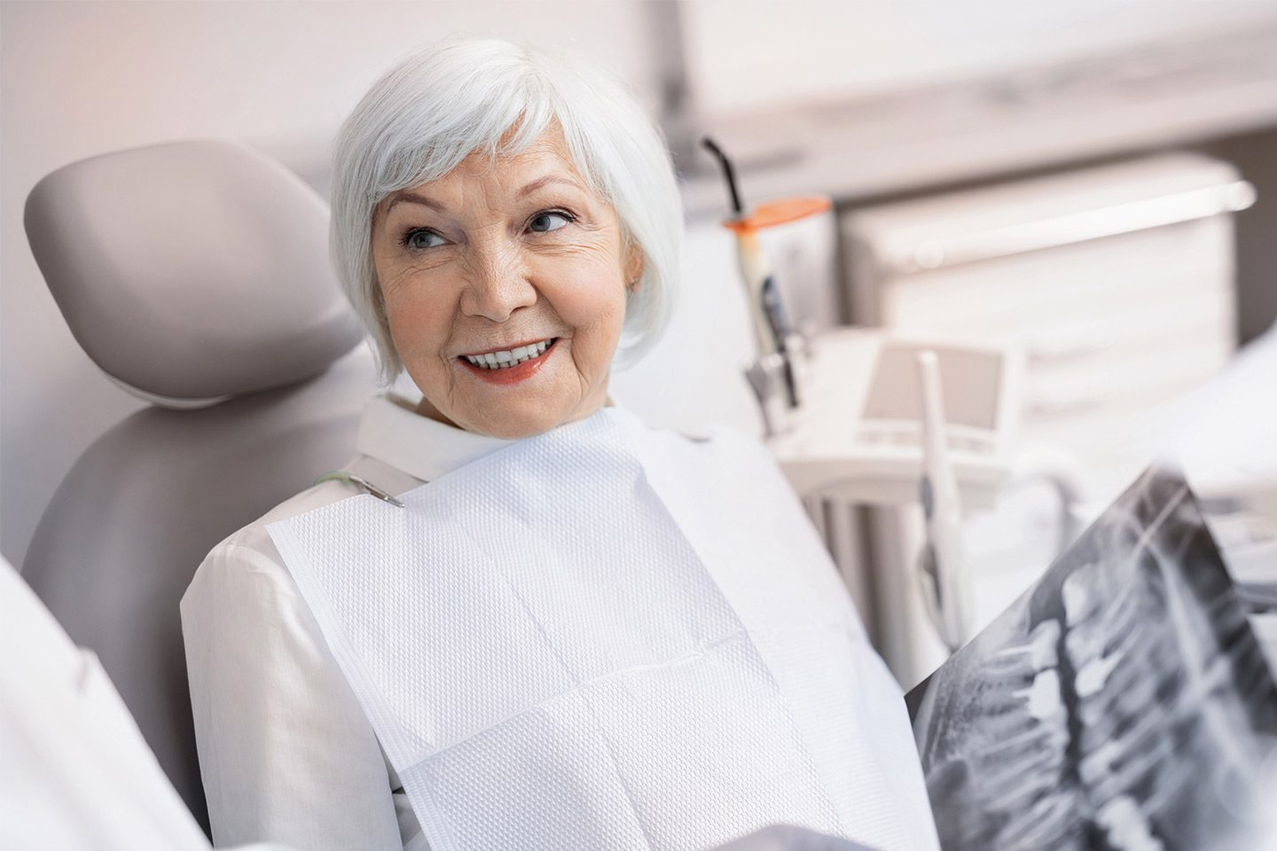 mature adult woman at dentist exploring teeth replacement options
