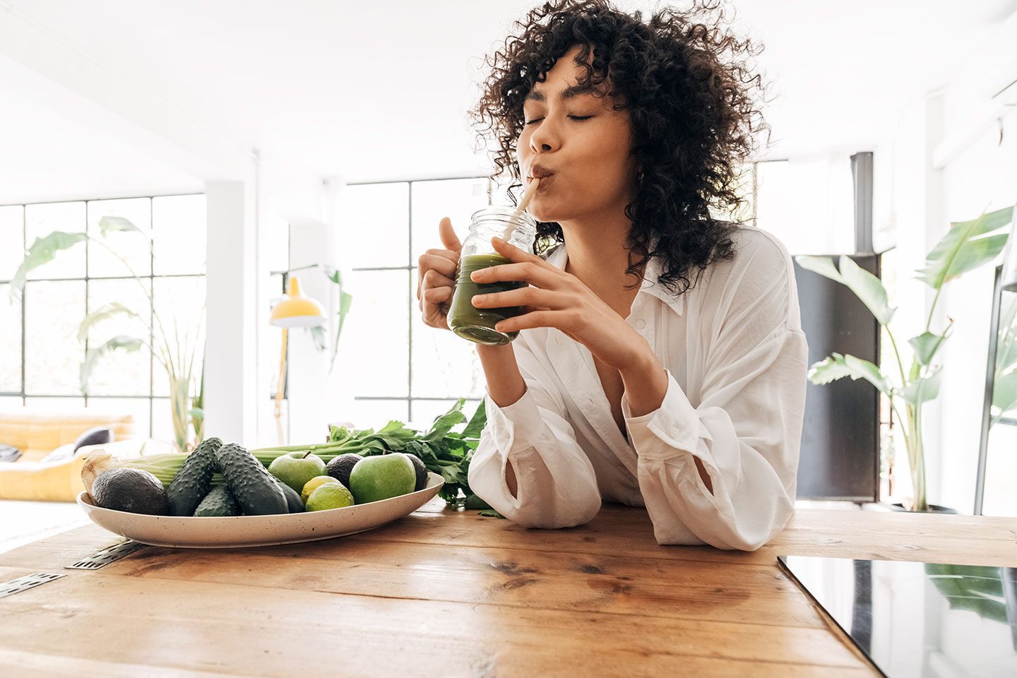 woman drinking a green smoothie