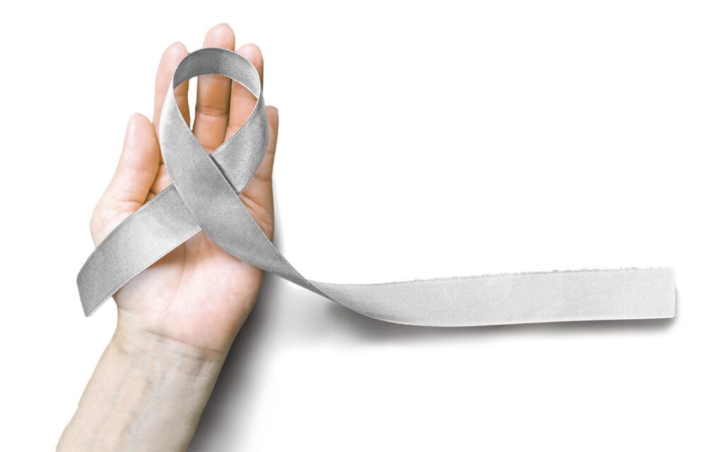 hand holding a gray parkinson's disease rememberence ribbon