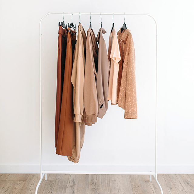 Creating a Capsule Wardrobe neutral clothes hanging on a wrack