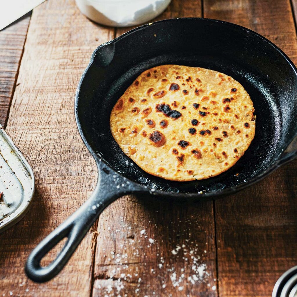 small cast iron pan with toasted food in it on top of wooden table