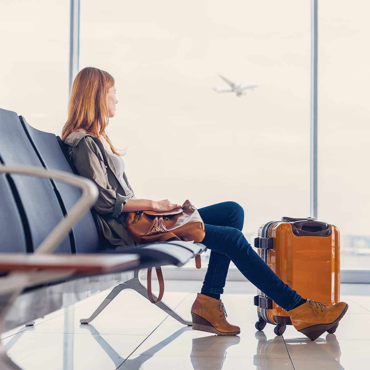 woman with airport anxiety looking outside through airport window